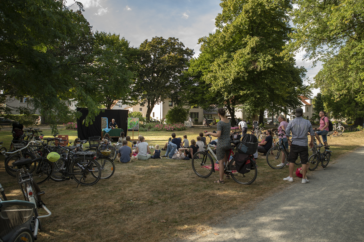 eine Gruppe Menschen mit Fahrrädern auf Gras