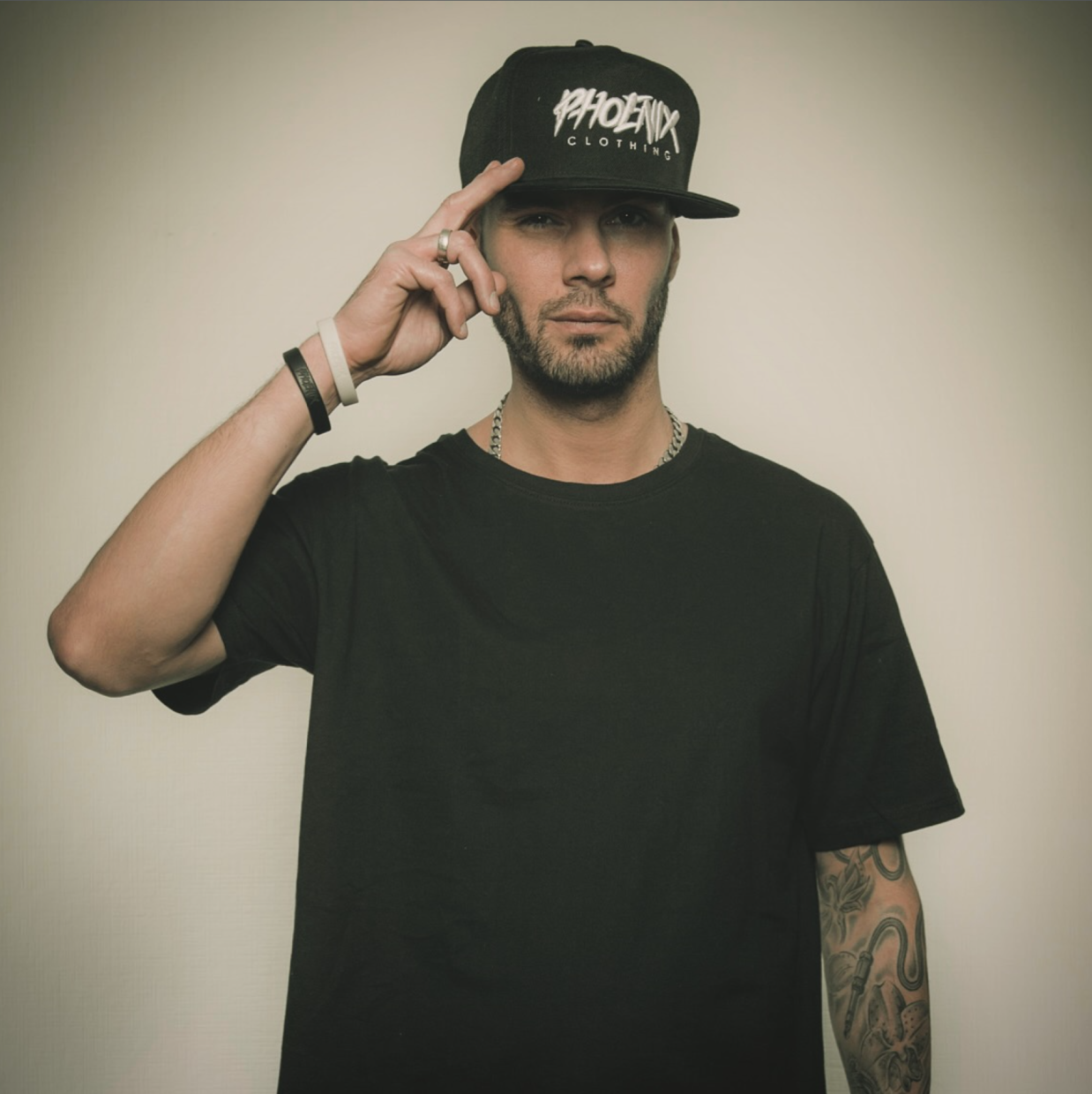 Mann in schwarzem T-Shirt und Cap blickt in Kamera.