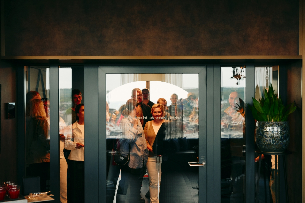 eine Gruppe Menschen im H1 vor einem Fenster