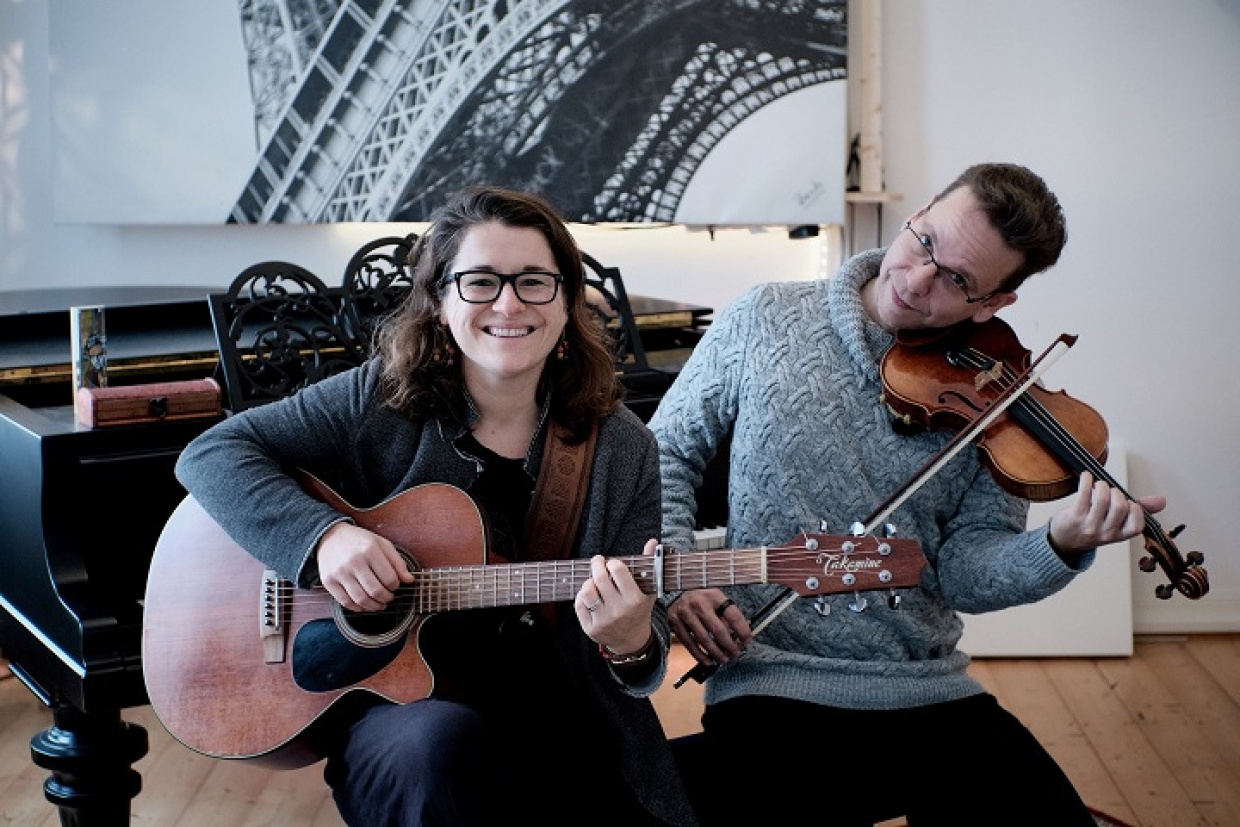 Frau an Gitarre und Mann mit Geige spielen zusammen