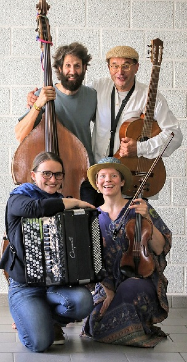 Vier MusikerInnen sitzen und stehen mit ihren Instrumenten