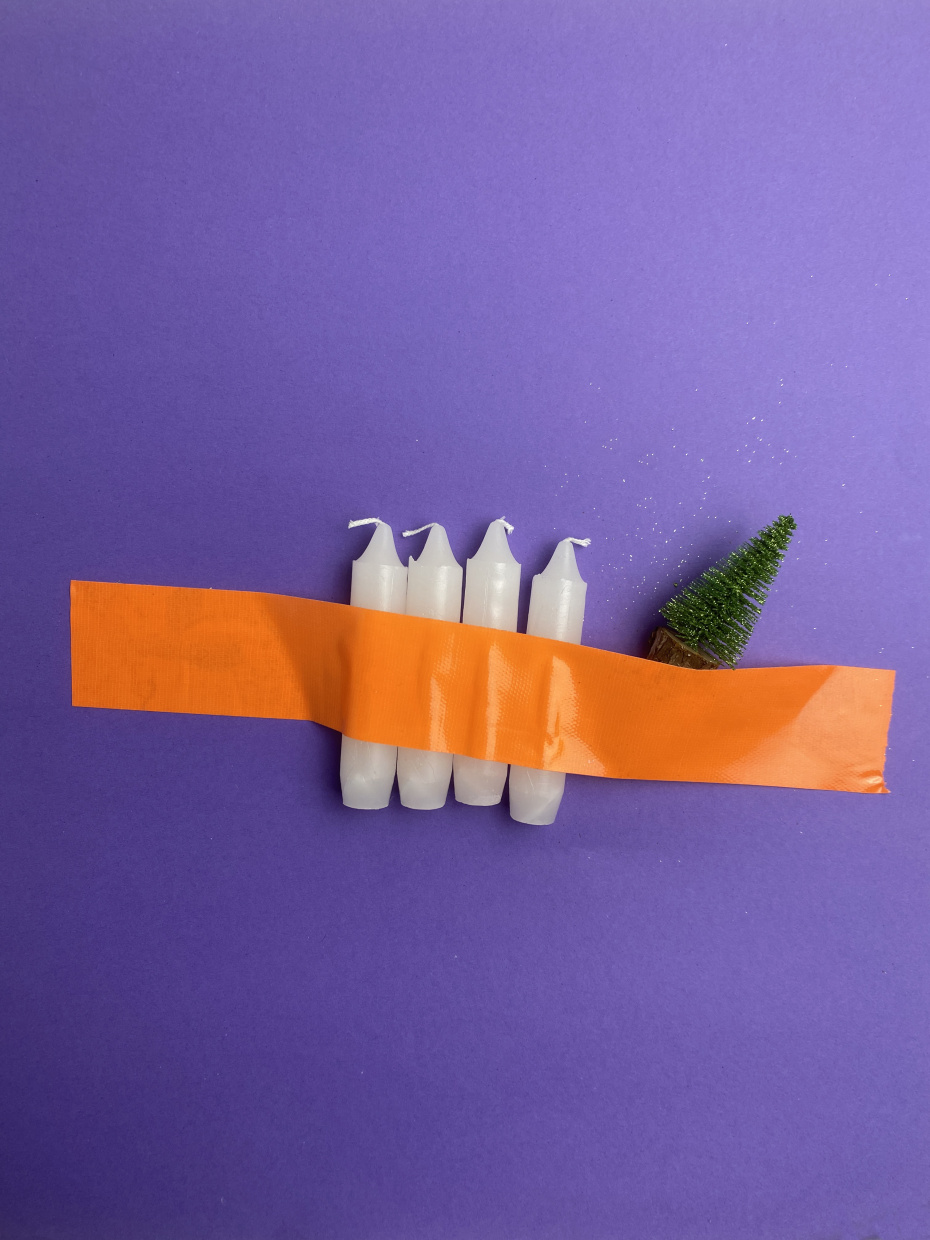 4 Kerzen und ein  kleiner Plastik-Weihnachtsbaum mit breitem Klebeband aufgeklebt.