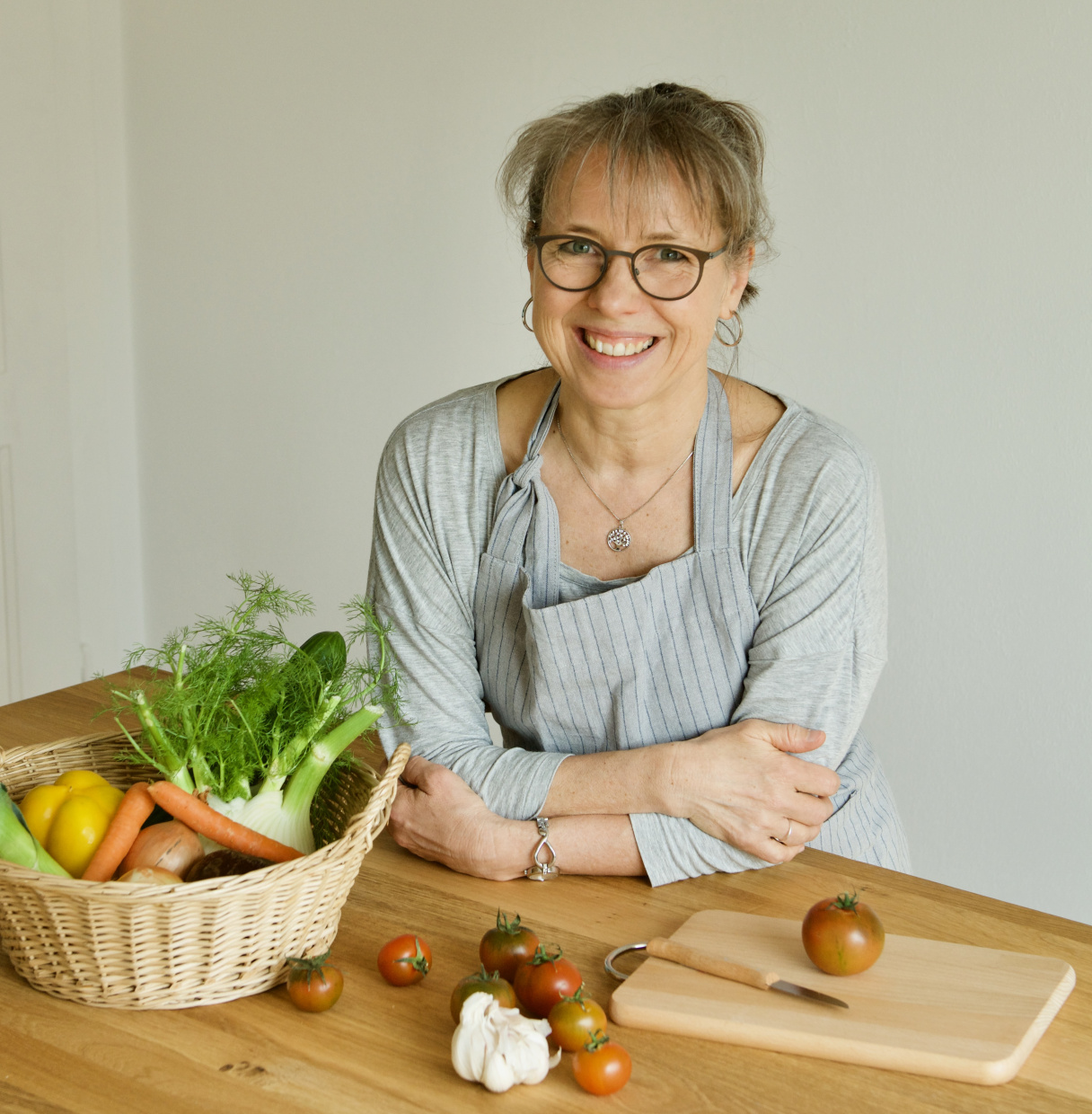 Foto der Kursleiterin in ihrer Lehrküche mit einem Korb Gemüse