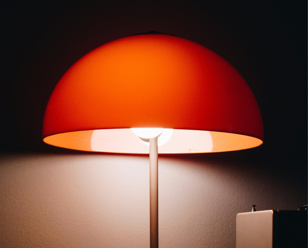 eine alte orangefarbene Stehlampe im 70er-Jahre-Design