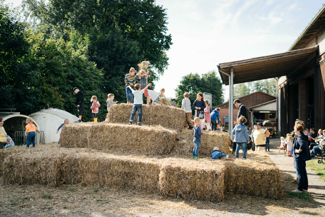 Kinder spielen auf einer Strohburg auf Gut Wilhelmsdorf