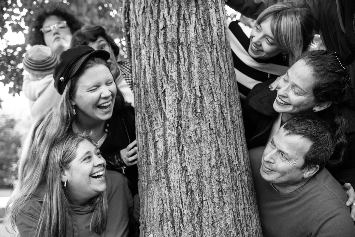eine Gruppe von Menschen um einen Baum versammelt