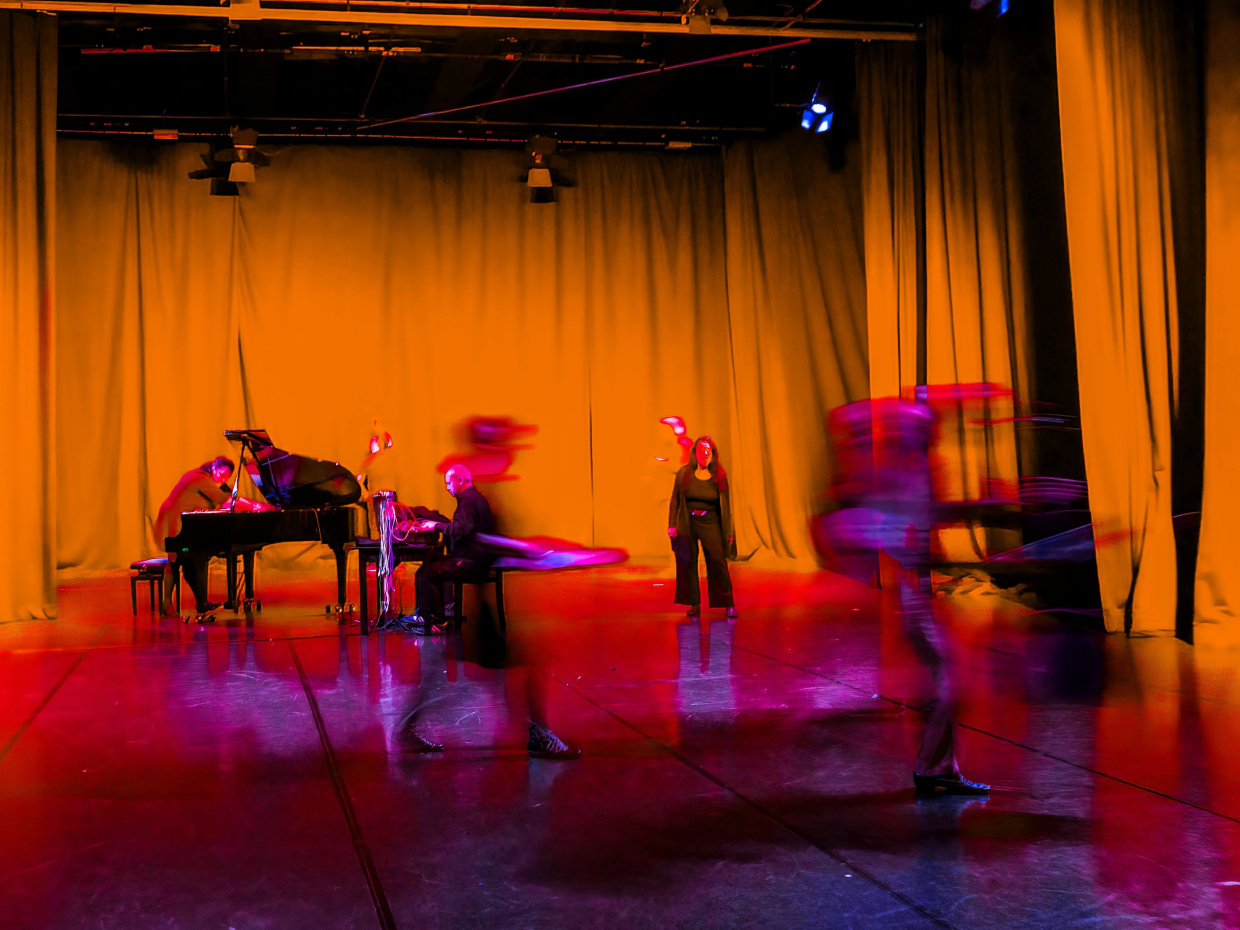 verschiedene Musiker*innen in Beegung auf einer Bühne
