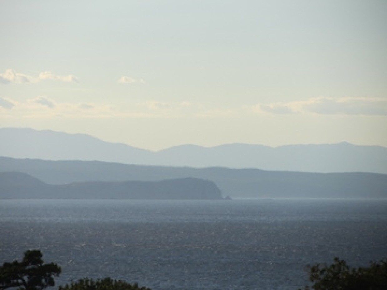 Meer und im Hintergrund Berge und Himmel