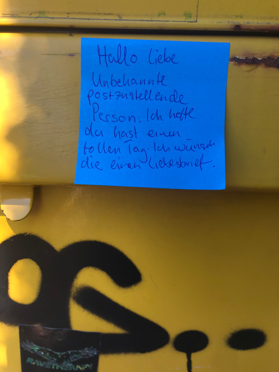 eine Botschaft auf einem blauen Post-It klebt auf einem Briefkasten