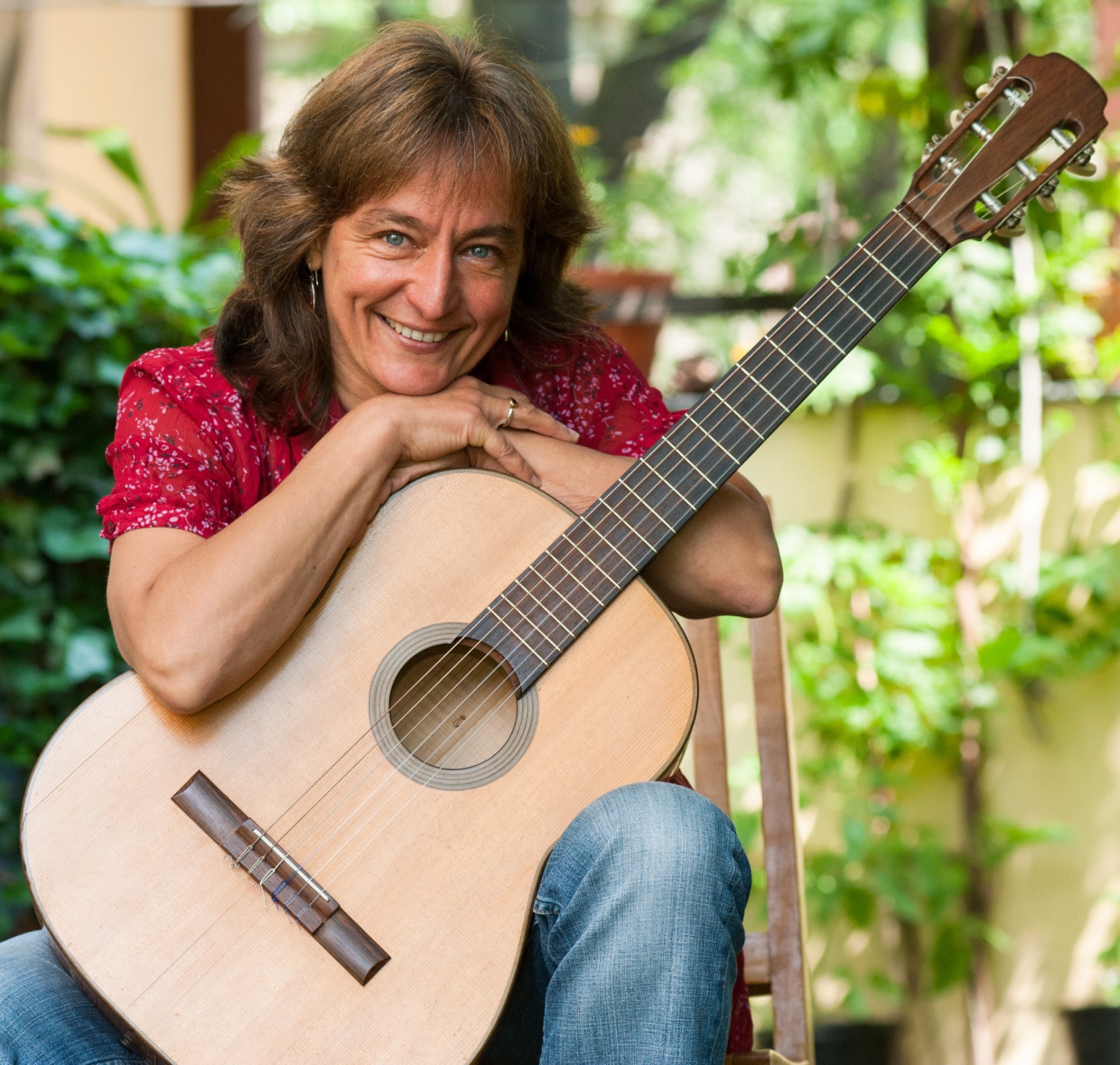 Foto der Künstlerin mit Gitarre, draußen