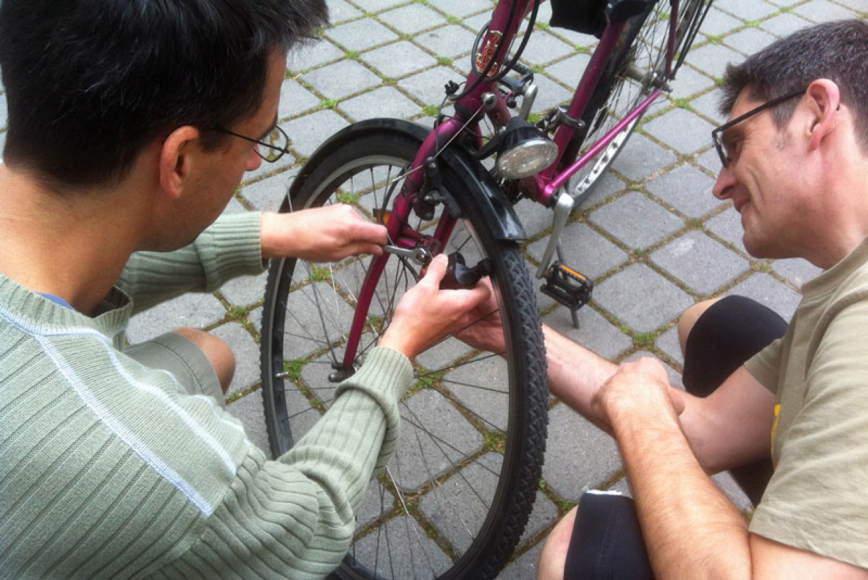 Zwei Männer beim Reparieren eines Fahrrades