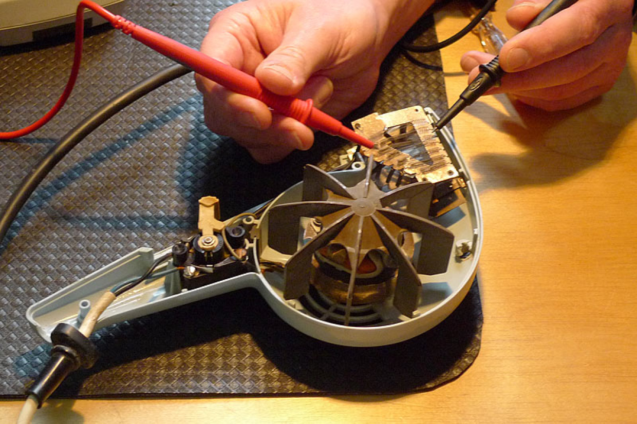 Ein geöffnetes elektrisches Gerät (Fön) wird repariert
