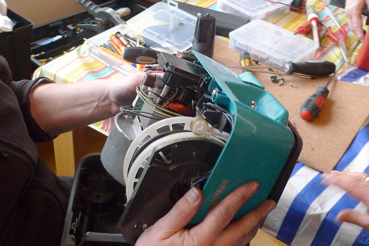 Ein geöffnetes elektrisches Gerät (Staubsauger) wird repariert