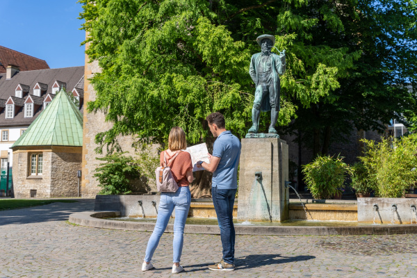 Mann und Frau stehen vor dem Leineweber-Denkmal