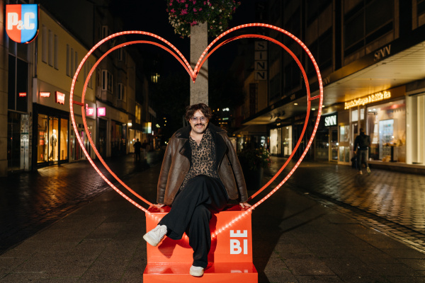 ein junger Mann sitzt in einem Herzrahmen