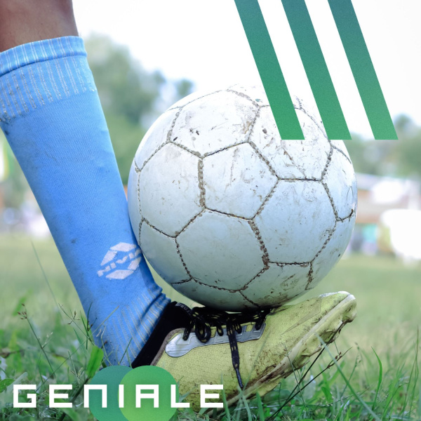 Ein Fuß mit Fußballschuhen an balanciert einen Fußball