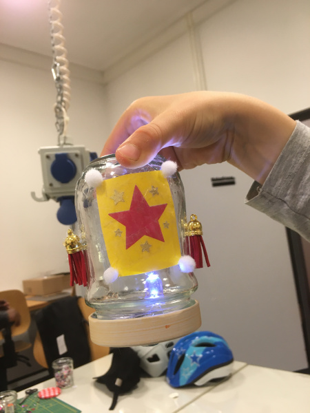 eine Hand hält ein selbstgebautes Kipplicht aus Glas