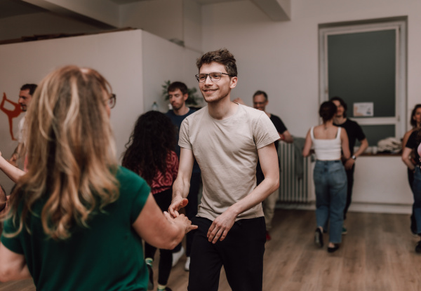 Im Vordergrund ein Paar, das Salsa tanzt. Im Hintergrund tanzen weitere Paare.