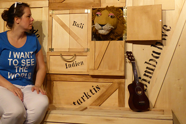 Musikerin Nike sitzt vor einem Löwen