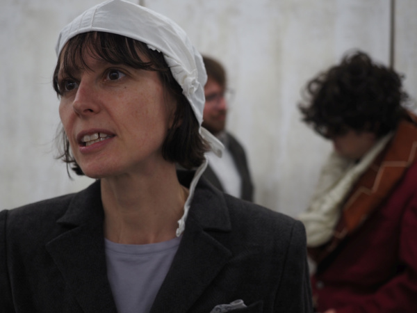 Eine Person im Vordergrund, zwei im Hintergrund