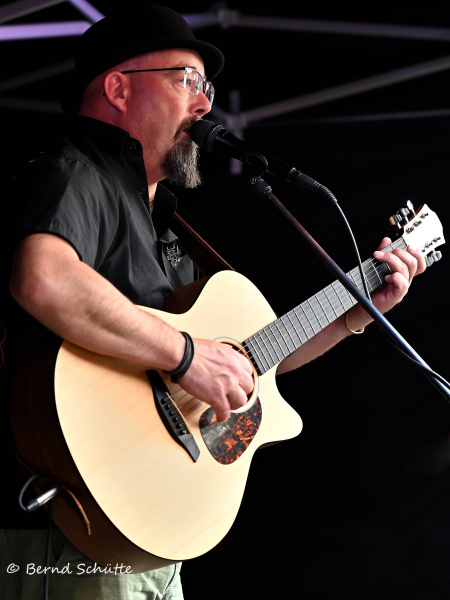 Patrick Shurety mit Gitarre auf einer Bühne