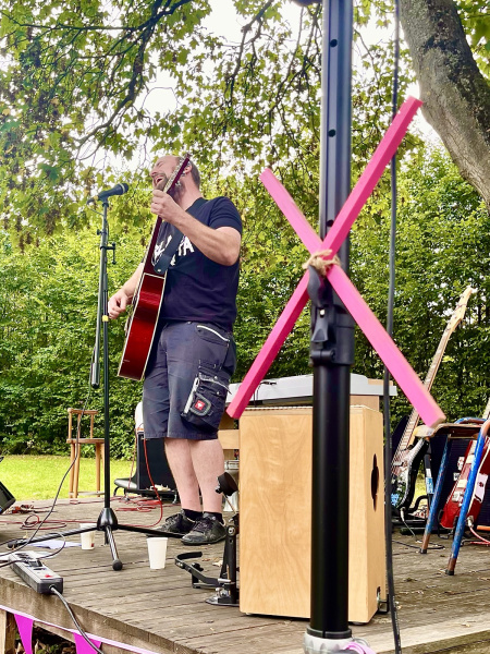 Gebäude der Rochdale Kaserne, pinkes Banner am Zaun und einige Menschen