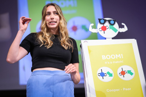 Eine Teilnehmerin bei FameLab Germany zeigt ihren Vortrag auf der Bühne.